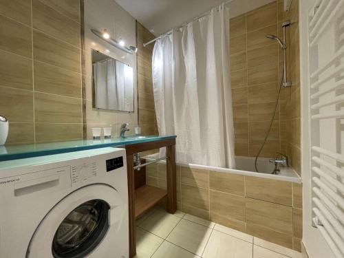 La salle de bains est pourvue d'un lave-linge et d'une baignoire. dans l'établissement Confortable appartement avec piscine, golf, et parking - FR-1-224-789, à LʼAiguillon-sur-Vie