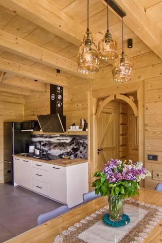 a kitchen with a vase of flowers on a table at Peak House in Kościelisko