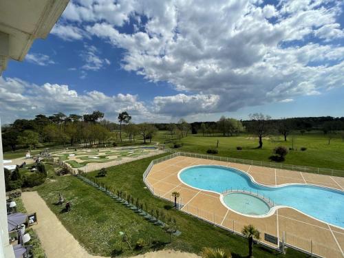 une vue aérienne d'une piscine dans un parc dans l'établissement Confortable appartement avec piscine, golf, et parking - FR-1-224-789, à LʼAiguillon-sur-Vie