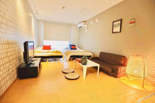 a small living room with a couch and a bed at TIME SHARING STAY Ikebukuro in Tokyo