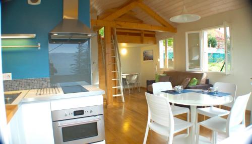 Il comprend une cuisine et un salon avec une table et des chaises. dans l'établissement Le cottage de Veyrier, très jolie vue Lac - LLA Selections by Location Lac Annecy, à Veyrier-du-Lac