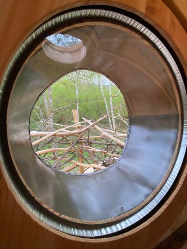 a roundorthole window with two vases on it at Les Cabanes De Pyrene in Cazarilh