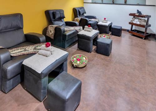 a living room with couches and ottomans at Club Mahindra Saj Mahabaleshwar in Mahabaleshwar