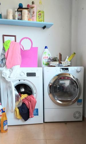 a washing machine and a washer in a room at Páteo memória, casa do beco in Setúbal