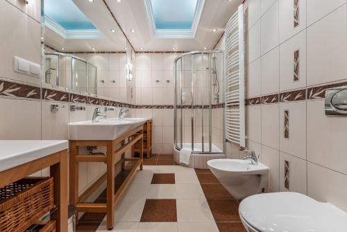 een badkamer met 2 wastafels en een toilet bij Centrum Wypoczynku i Rehabilitacji Umina in Czorsztyn