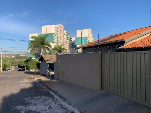 a street with a fence and buildings in the background at Casa Thermas Olimpia I - 150 metros do Thermas dos Laranjais in Olímpia