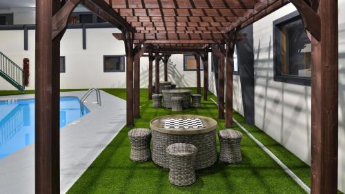 an outdoor patio with a table and stools next to a pool at Holiday Inn Great Falls-Convention Center by IHG in Great Falls