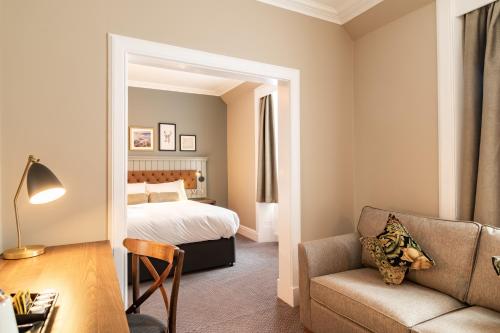 a bedroom with a bed and a living room with a couch at The Hawes Inn by Innkeeper's Collection in Queensferry