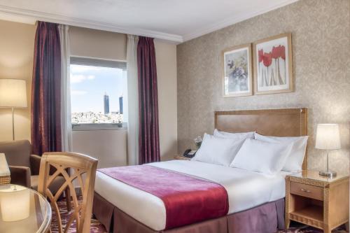 a hotel room with a bed and a window at Geneva Hotel in Amman