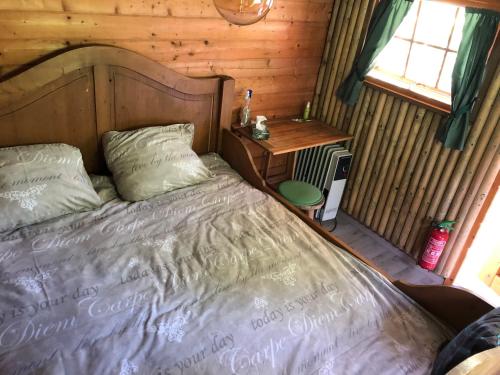 uma cama num quarto com uma parede de madeira em Treehouse op het platteland van Huize Ouwervelden em Centrum