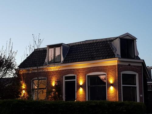 a brick house with lights on the front of it at Villa Amsteldijck (8km from Amsterdam) in Ouderkerk aan de Amstel