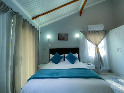 a bedroom with a large bed with blue pillows at Kv Luxury Guest House in Johannesburg