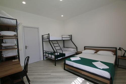 a bedroom with two bunk beds and a desk at Polifonia Inn Borjomi in Borjomi