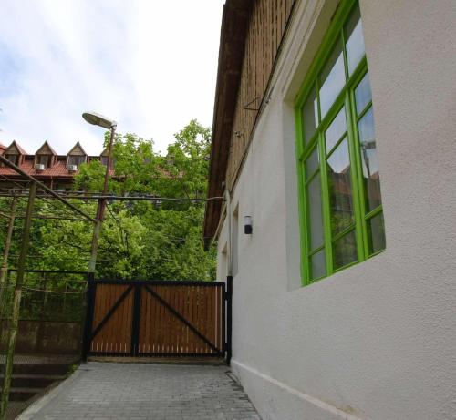 a door with a green window and a fence at Polifonia Inn Borjomi in Borjomi