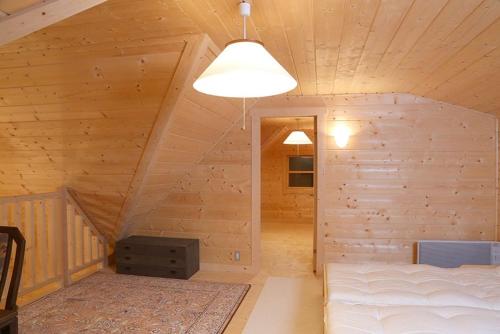 那須塩原市にあるコテージ　チャオのベッド付きの木製キャビン内のベッドルーム1室