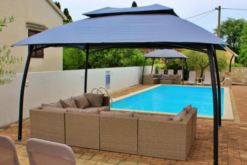 a large blue umbrella next to a swimming pool at Apartments Kimm in Poreč