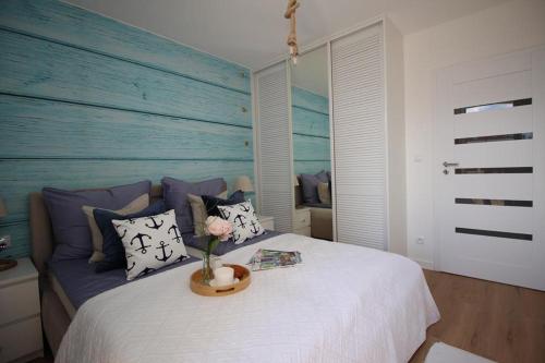 ein Schlafzimmer mit einem weißen Bett und einer blauen Wand in der Unterkunft Morskie klimaty - Rejs in Świnoujście