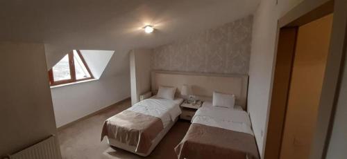 سرير أو أسرّة في غرفة في Kaspia Yeddi Gozel Hotel