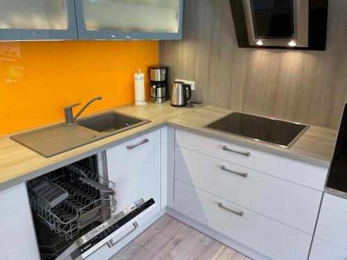 a small kitchen with a sink and a dishwasher at Marions Apartments Greetsiel in Greetsiel