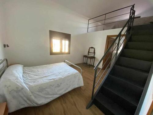 a bedroom with a bed next to a staircase at El cortijo del abuelo pepe in Alhendín