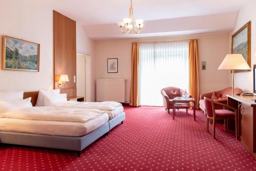 ケールハイムにあるGasthof Stockhammerのベッド、デスク、椅子が備わるホテルルームです。