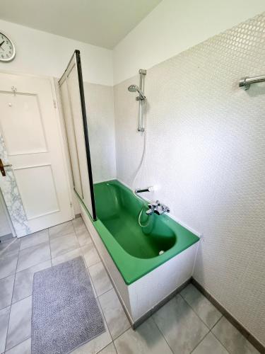 ピディングにあるFerienwohnung Staufenblickの緑色の浴槽とシャワー付きのバスルーム