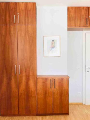 a wooden cabinet in a room with a picture on the wall at Planai Ski Slope Appartements in Schladming
