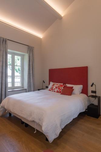 a bedroom with a large bed with a red headboard at Domaine de Panery in Pouzilhac