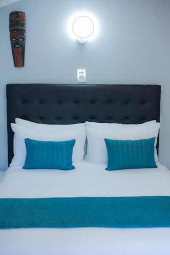 a bedroom with a large bed with blue pillows at Kv Luxury Guest House in Johannesburg