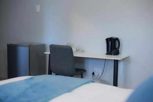 a room with a desk with a chair and a computer at Kv Luxury Guest House in Johannesburg