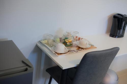a table with a tray of dishes and a chair at Kv Luxury Guest House in Johannesburg