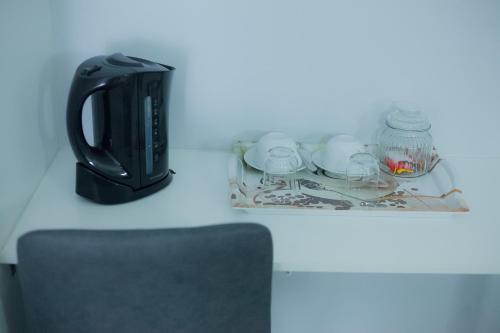 a table with a coffee pot and glasses on it at Kv Luxury Guest House in Johannesburg