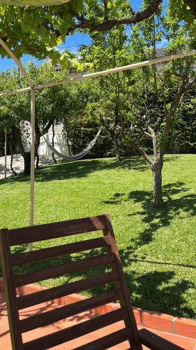 a wooden bench sitting in a field of grass at Citrus Tree House, private pool and garden. in Angeja