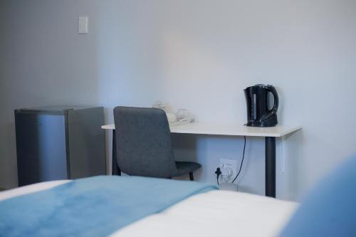 a room with a desk with a chair and a computer at Kv Luxury Guest House in Johannesburg