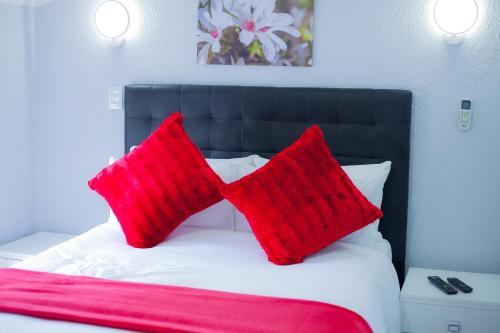 two red pillows sitting on top of a bed at Kv Luxury Guest House in Johannesburg