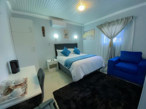 a bedroom with a blue bed and a blue chair at Kv Luxury Guest House in Johannesburg