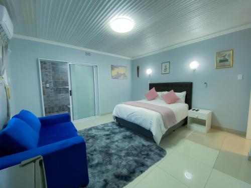 a bedroom with a bed and a blue couch at Kv Luxury Guest House in Johannesburg