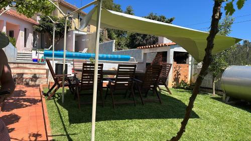 a table and chairs under a tent in a yard at Citrus Tree House, private pool and garden. in Angeja