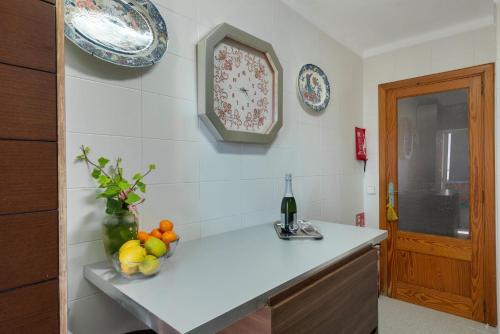 a kitchen with a bowl of fruit and a bottle of wine at Violet House - Alcúdia in Alcudia
