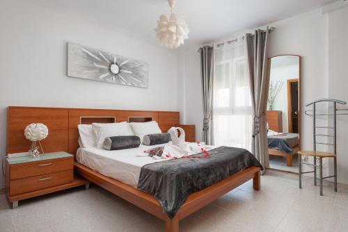 a bedroom with a large bed and a mirror at Violet House - Alcúdia in Alcudia