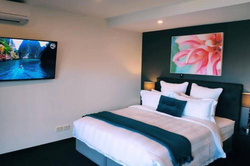 a bedroom with a large bed with two pictures on the wall at Lovely Apartment- Amazing Lake & Mountain Views in Queenstown