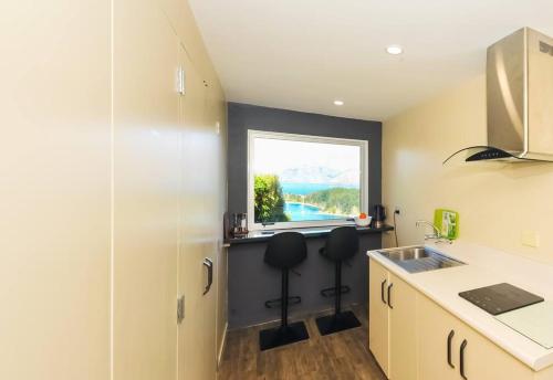 a kitchen with a sink and a window at Lovely Apartment- Amazing Lake & Mountain Views in Queenstown