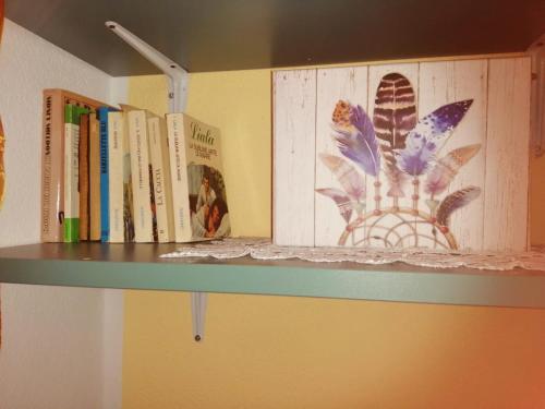 un estante con libros en una habitación en Appartamenti le conchiglie e le Stelle Marine, en Cala Gonone