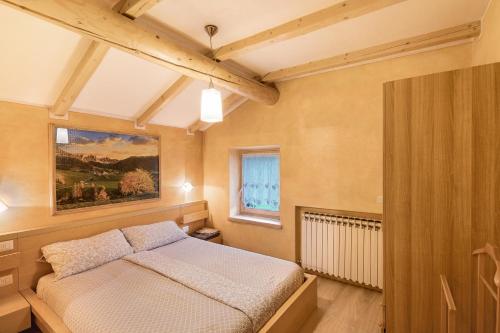 una camera da letto con un letto e un dipinto sul muro di Appartamento Giada a Livigno