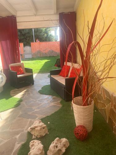 a patio with two chairs and a potted plant at Appartamento Villa Serena due in Maracalagonis