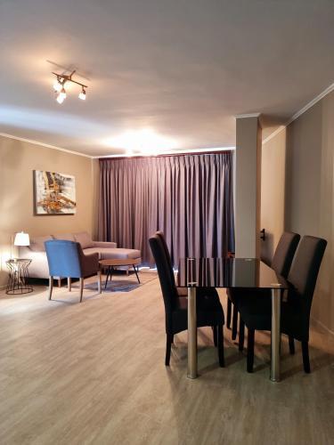 a living room with a table and chairs and a couch at Island Club by Smart City Stays in Cape Town