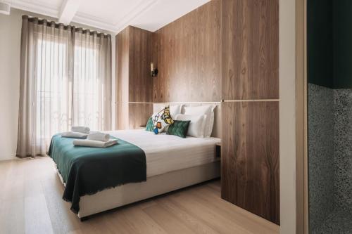 - une chambre avec un grand lit et des murs en bois dans l'établissement HIGHSTAY - Luxury Serviced Apartments - North Marais 1, à Paris