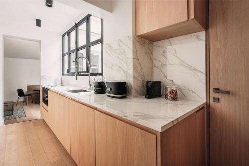 eine Küche mit Marmorarbeitsplatten und einem Waschbecken in der Unterkunft HIGHSTAY - Luxury Serviced Apartments - Place Vendôme Area in Paris