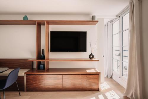 een woonkamer met een flatscreen-tv aan de muur bij HIGHSTAY - Luxury Serviced Apartments - Place Vendôme Area in Parijs