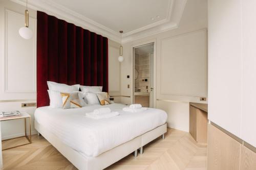 a bedroom with a large white bed and a red window at HIGHSTAY - Luxury Serviced Apartments - Champs-Elysées in Paris
